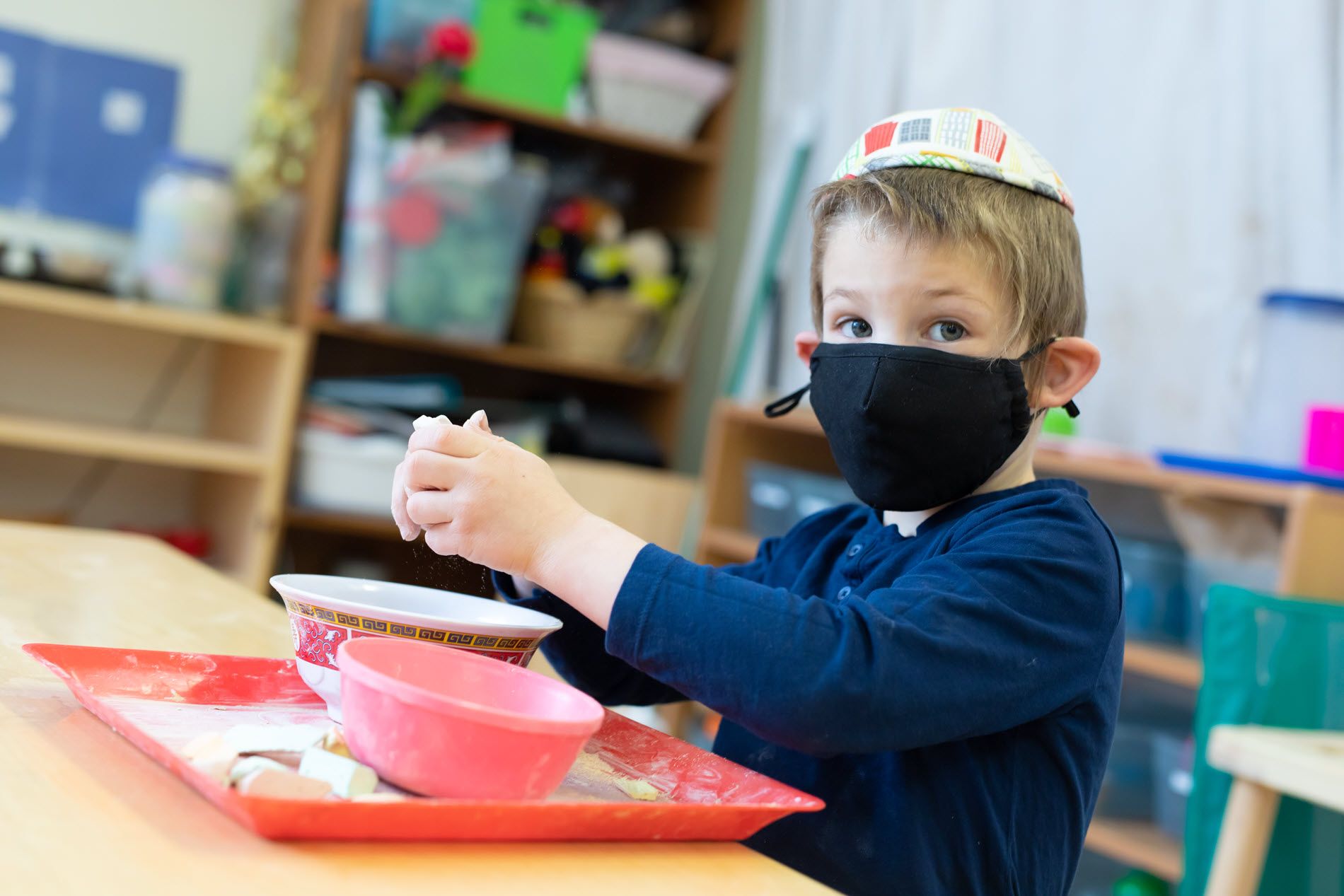 Young boy in mask in class.